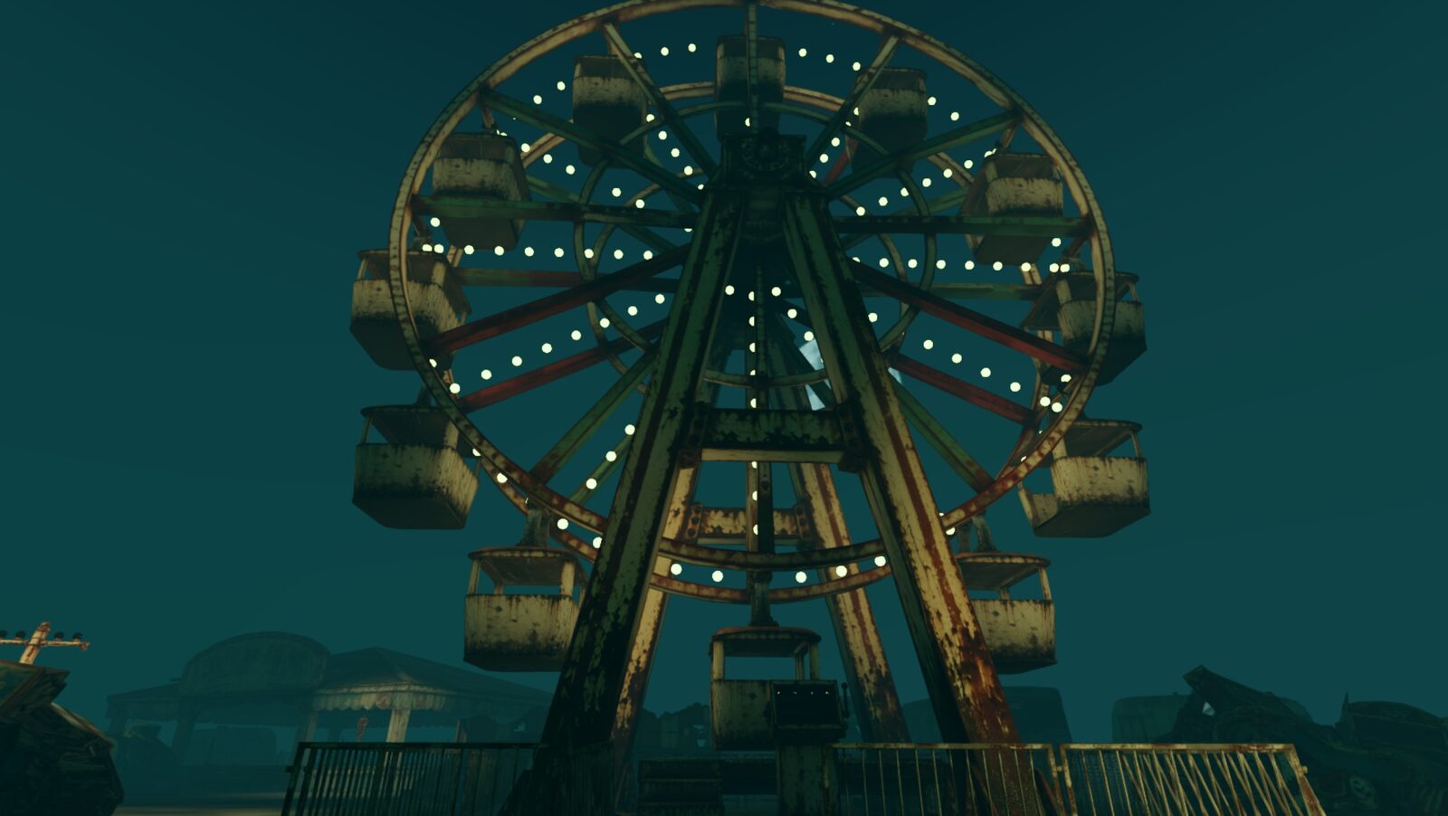 The Ferris wheel lit up against the night sky, rows of bulbs around its rim and gondolas hanging still