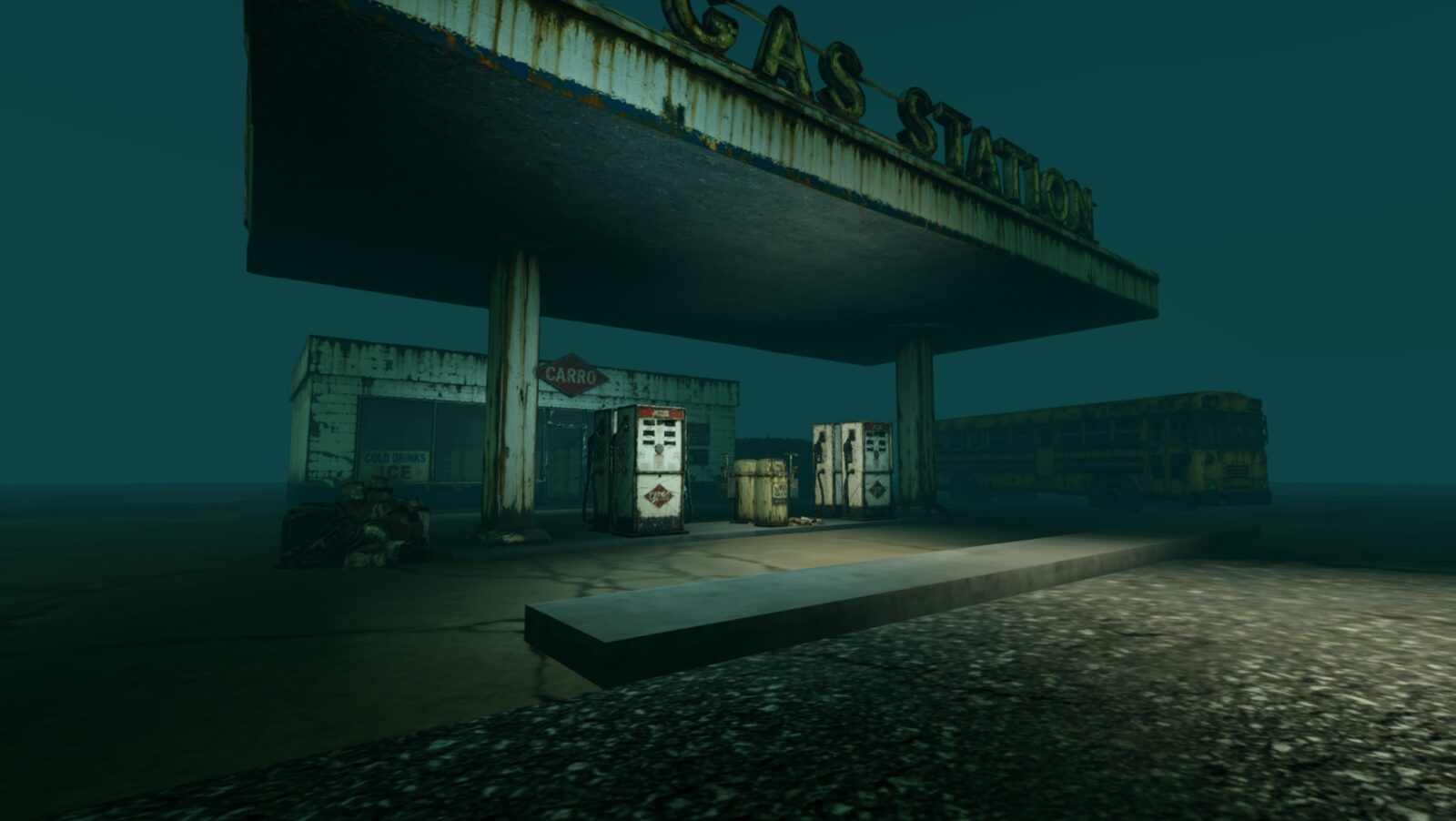 The abandoned gas station at night, its pumps under the canopy and an old school bus beyond